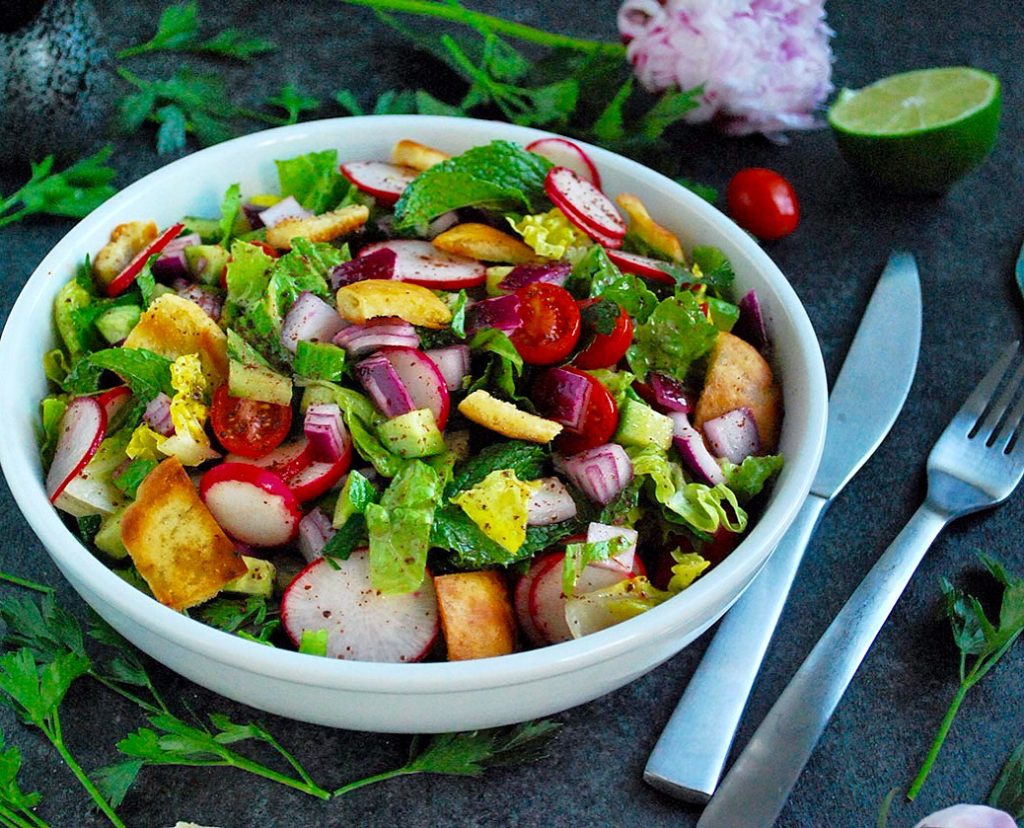 Fattoush is a vegan salad that is a staple on Middle Eastern dinner tables. Crunchy pita bread croutons, flavorful veggies and a tangy sumac dressing!