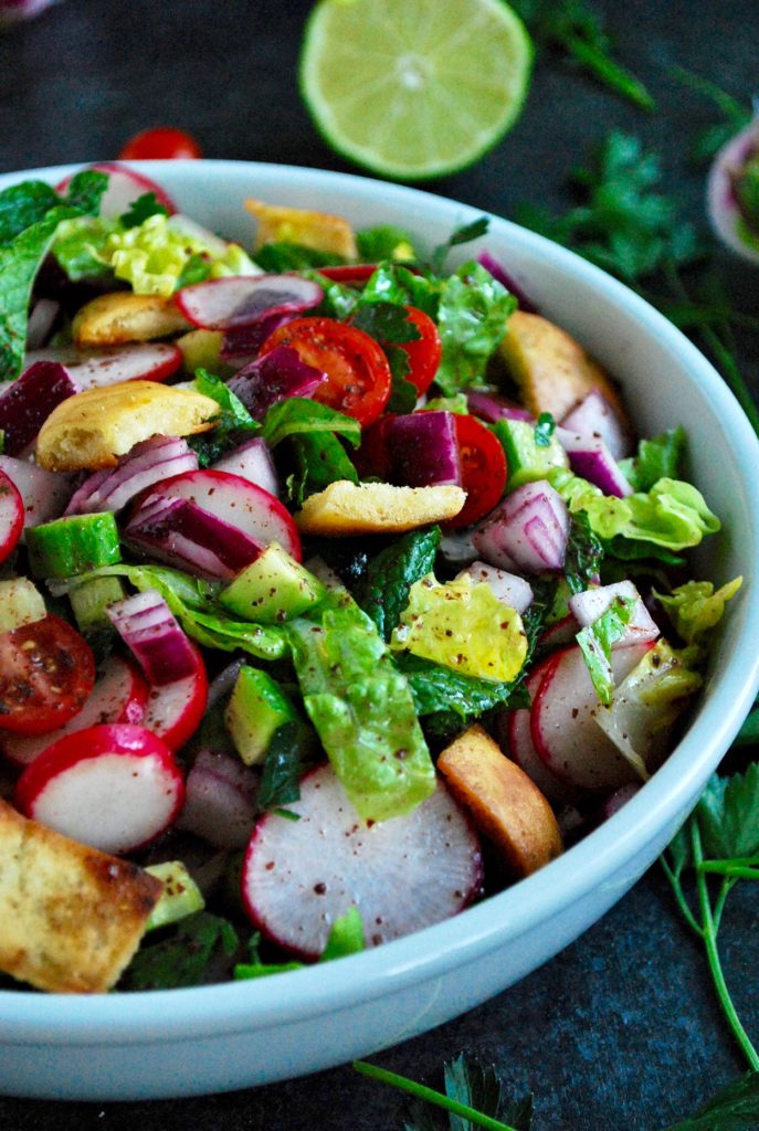 Fattoush is a vegan salad that is a staple on Middle Eastern dinner tables. Crunchy pita bread croutons, flavorful veggies and a tangy sumac dressing!